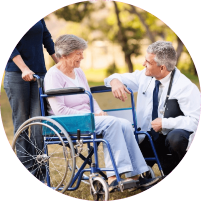 Azuba helps Doctos Doctor kneeling, talking to wheelchair bound senior